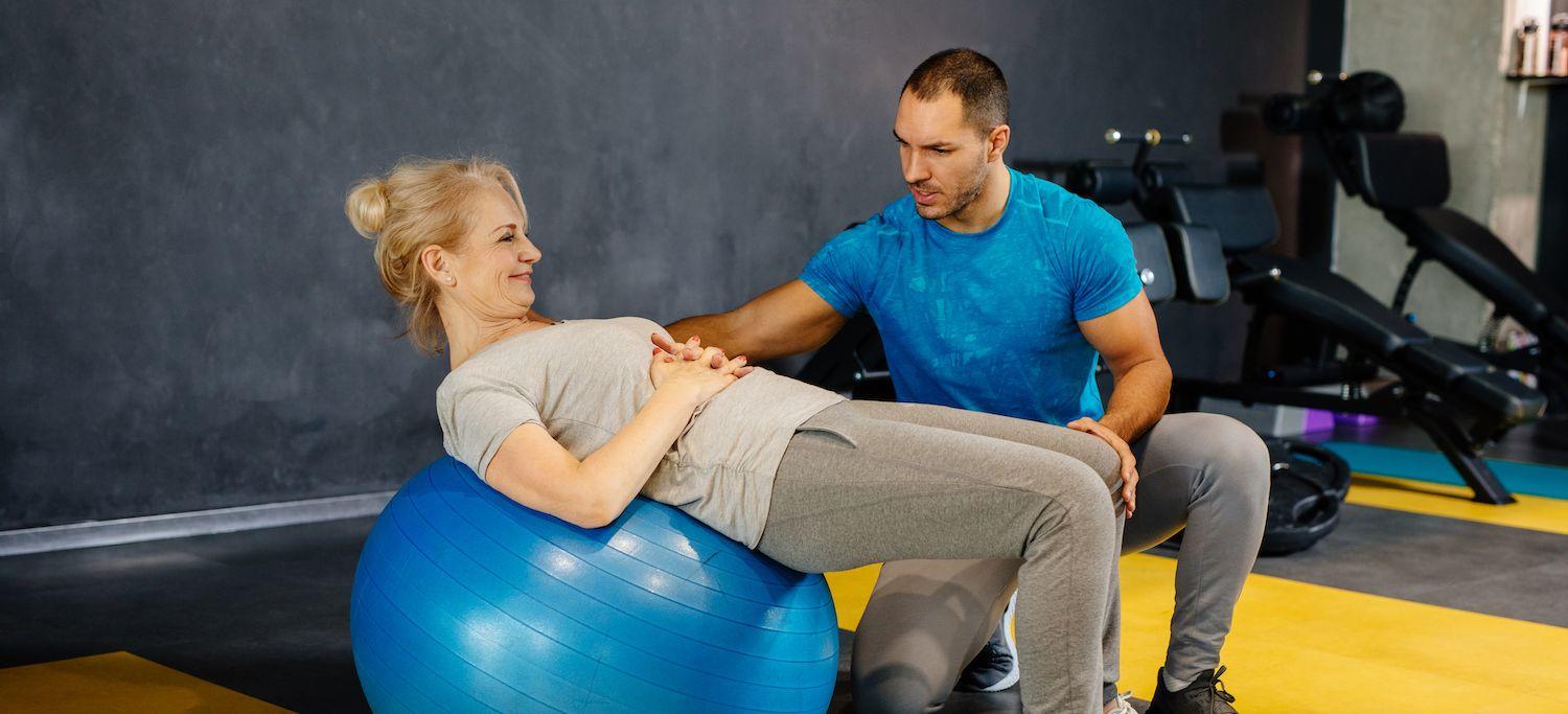 Older Woman Receiving Physical Training on an Exercise Ball as Part of a Chronic Pain Management Plan