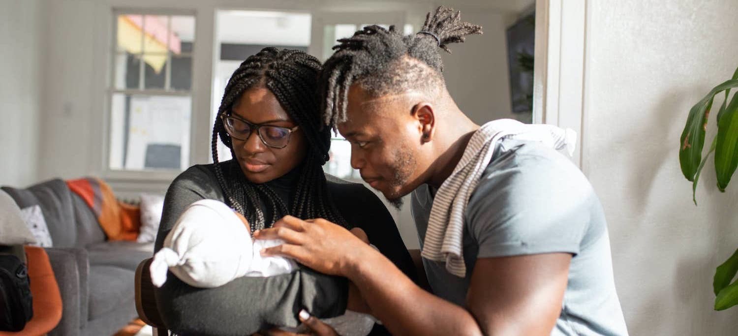 Mother and father caring for and gazing at their infant child