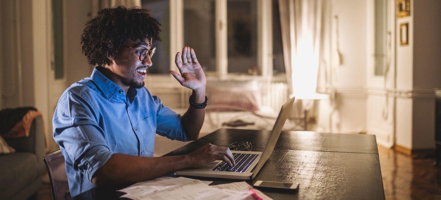 Young Man Raising His Hand During an Online Postgraduate Dentistry Degree Video Chat