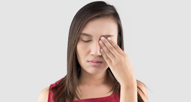 Women rubbing eye in pain