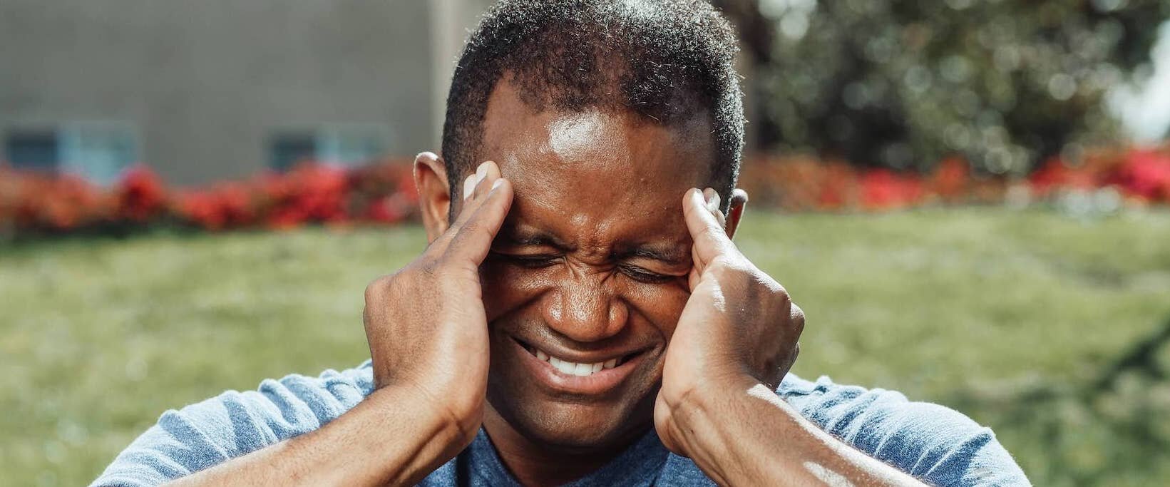 Man grabbing his head in pain