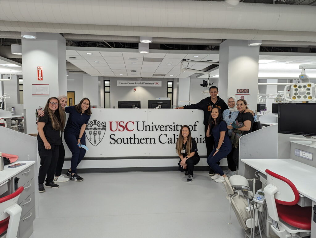 OPR students smiling in from of the USC sign at the clinic.