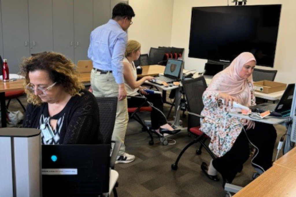 Geriatric Dentistry students working on computers with faculty member.