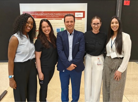 Community Oral Health faculty and students taking a picture in front of their research poster.